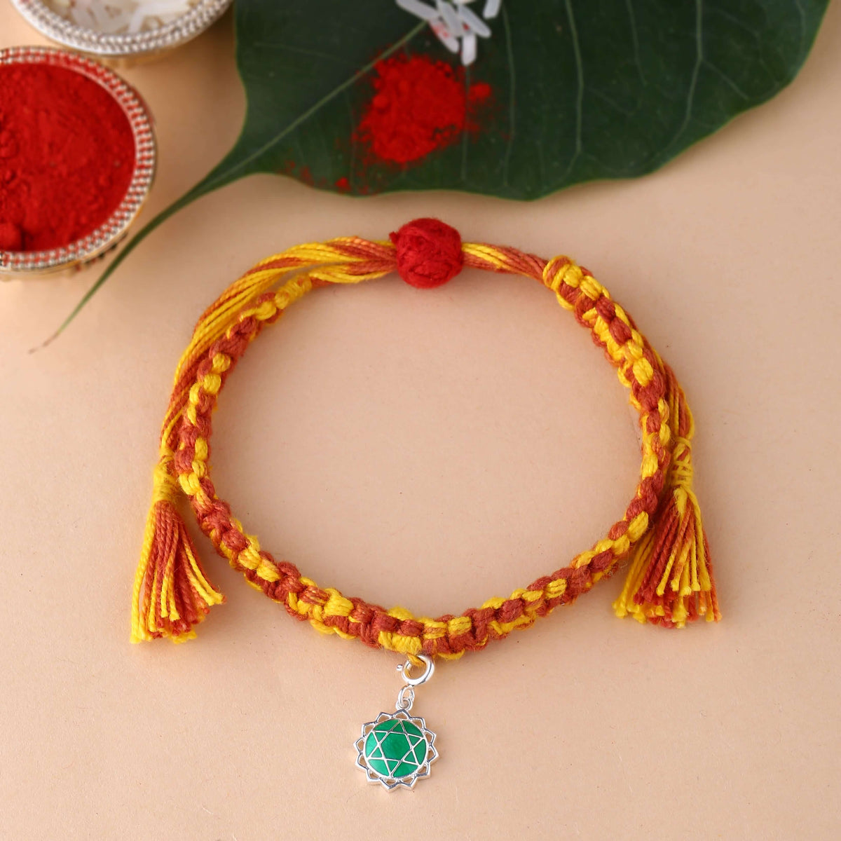 silver Anahata chakra rakhi with green colour meenakari work