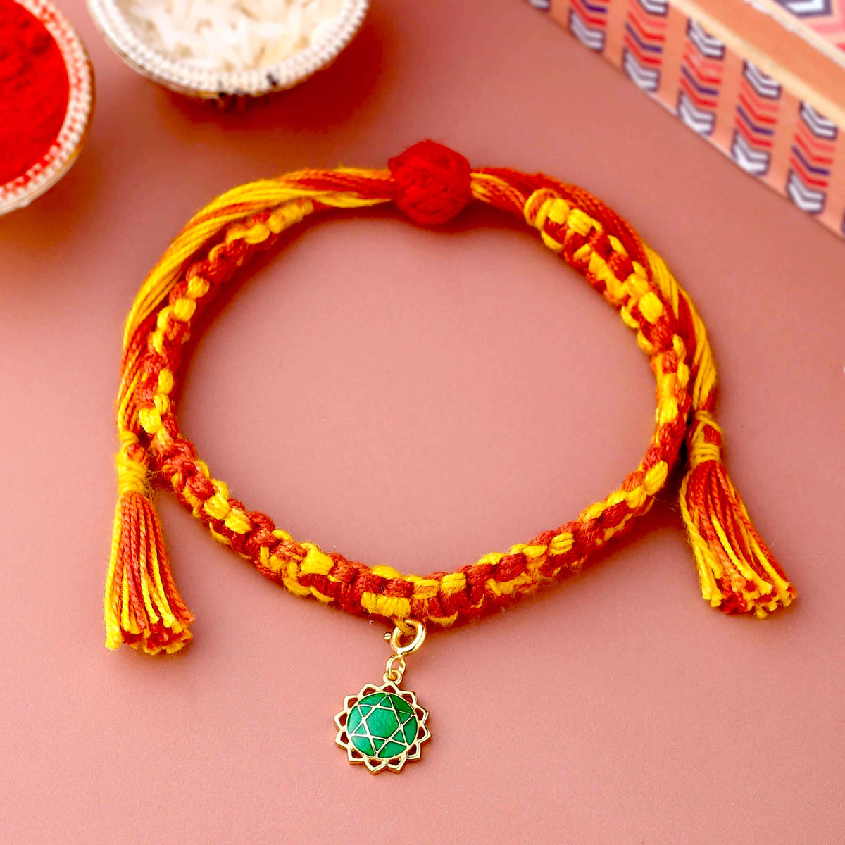 Gold Anahata chakra rakhi with green colour meenakari work
