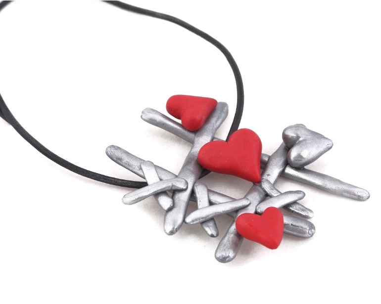 Polymer clay tic-tac-toe neckpiece strung on a black leather cord