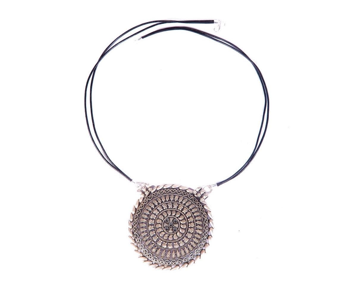 Small round pendant strung in twin leather cords