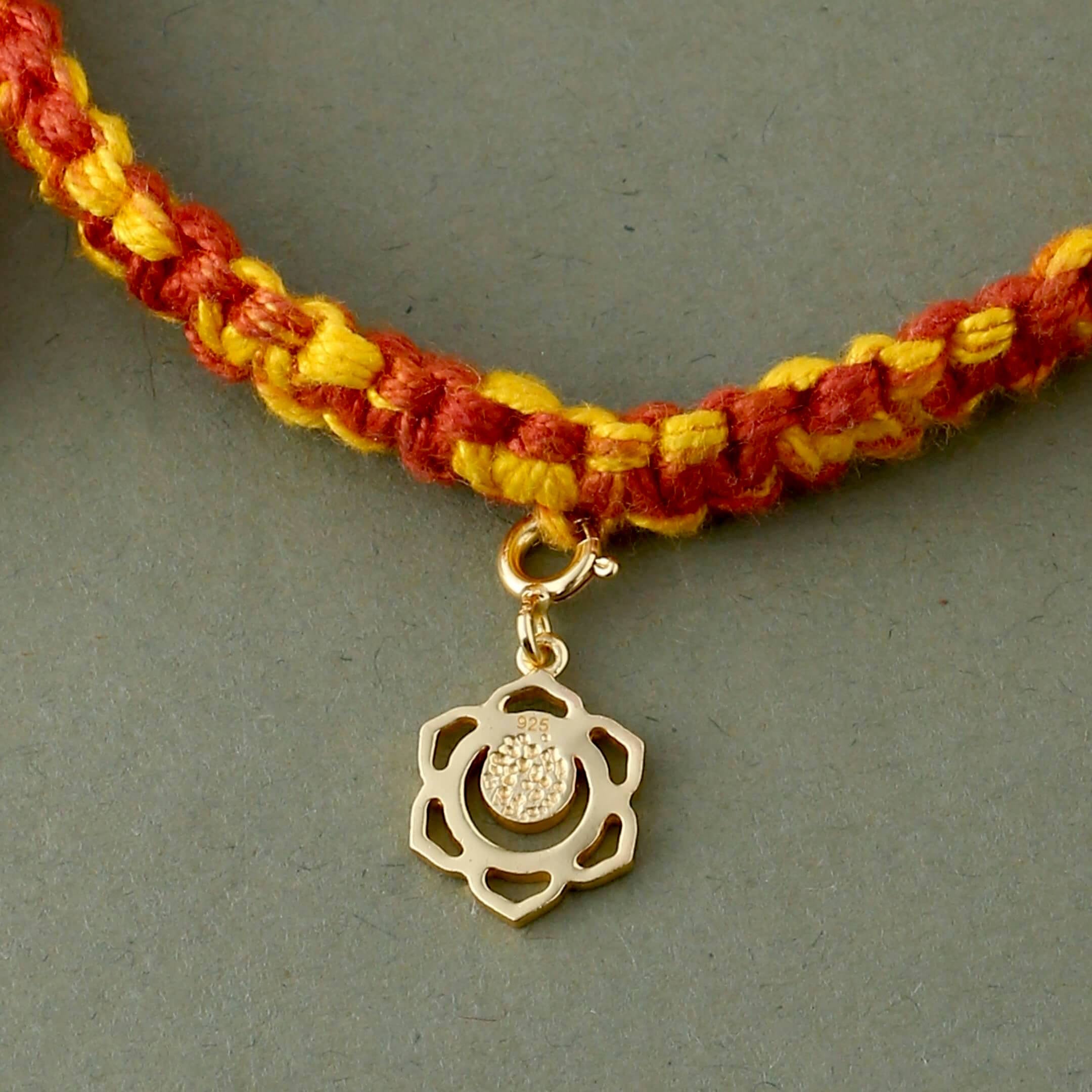 Swadhisthana chakra gold rakhi in braided mauli