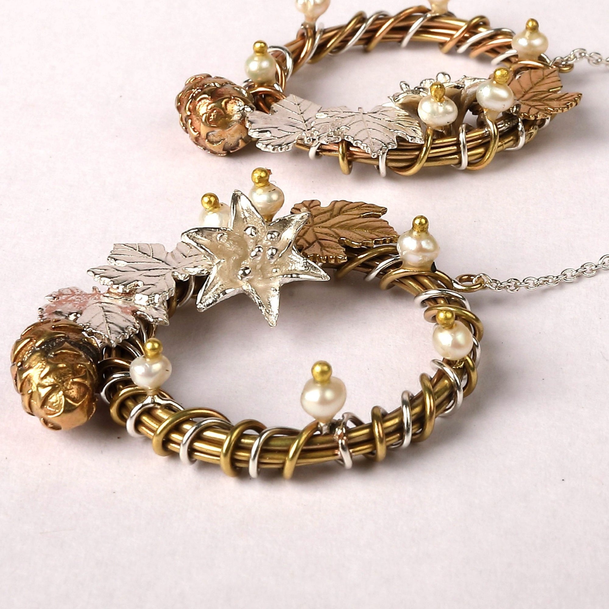 Danglers embellished with silver & brass ivy leaves, brass pine cone, fresh water pearl buds & a silver flower