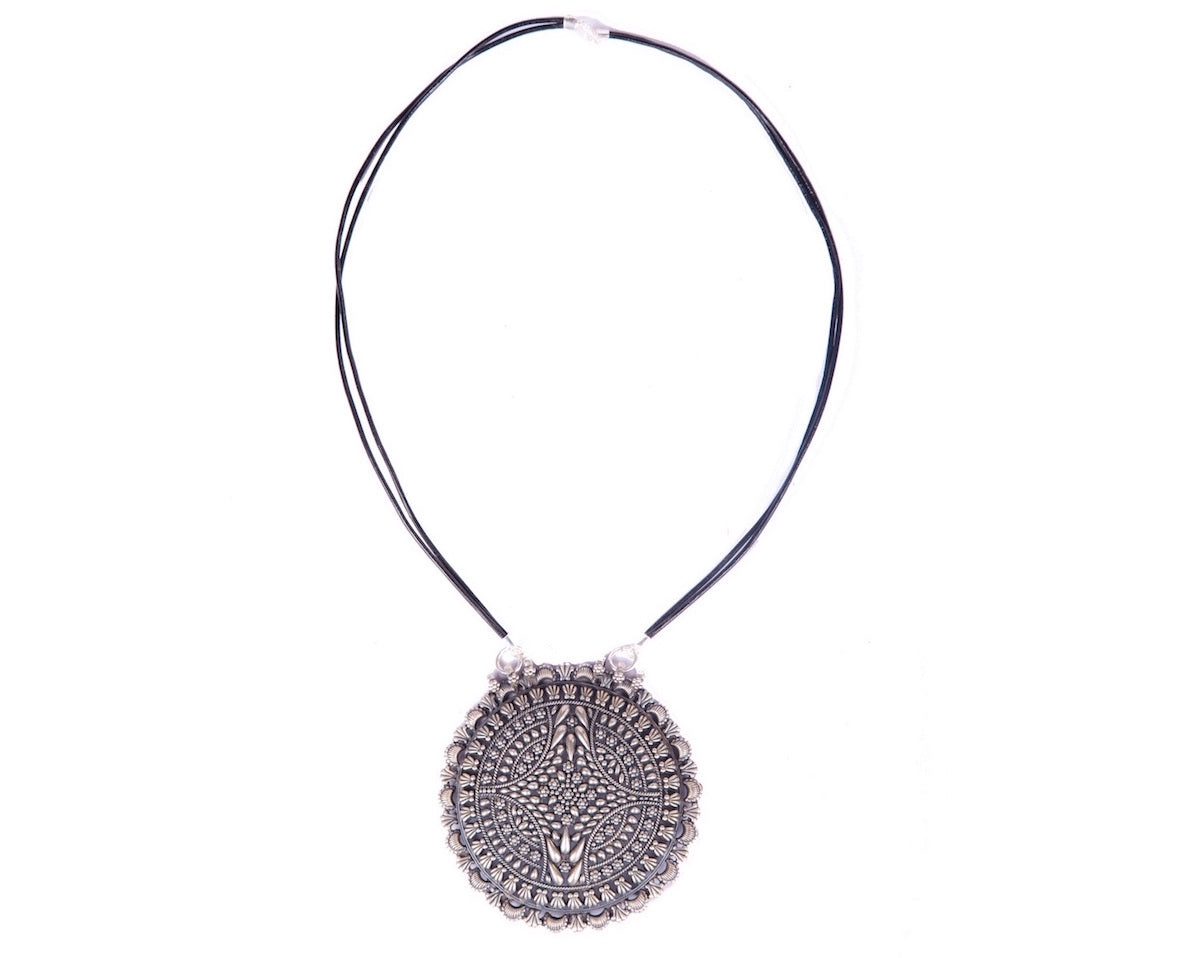 Oxidized sterling silver round pendant strung in twin leather cords